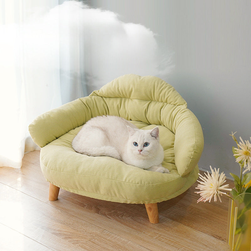White cat resting on a cozy light green wooden pet bed with cushioned modern design legs