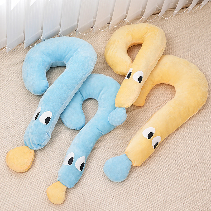 Two plush moon-shaped pet pillows in soft pastel blue and yellow with playful eyes on a beige floor