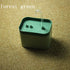 Compact forest green automatic cat water fountain with a sleek modern design on textured surface