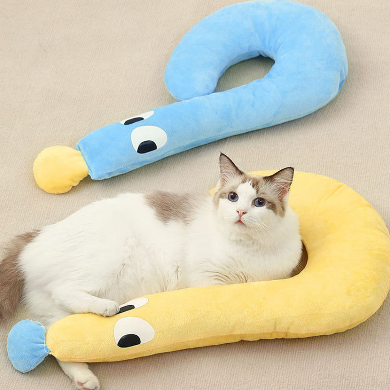 Cat resting on a soft plush crescent cushion with a playful, cozy design in a modern home setting