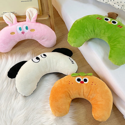 Set of four colorful U-shaped plush pillows with playful animal and fruit designs on soft surfaces