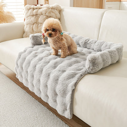 Small dog sitting on a plush, thickened gray thermal mat on a modern white sofa in a cozy living room